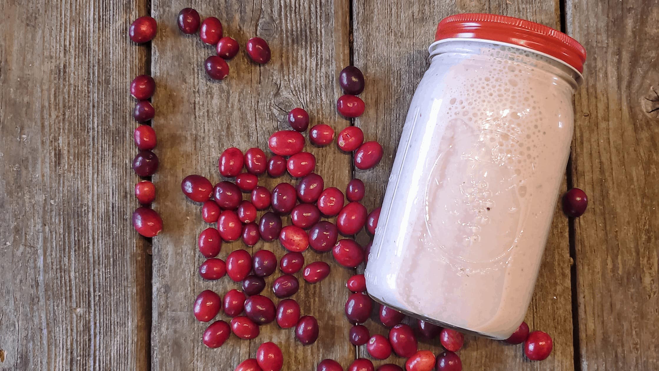 cranberry baobab smoothie on a table with cranberries