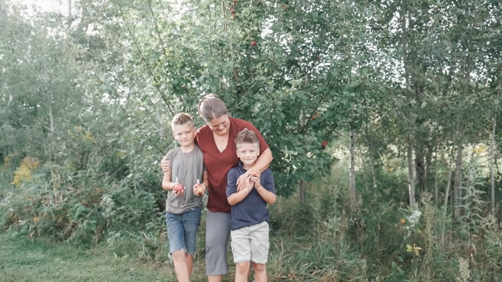 Life skills to teach kids - mom and boys harvesting apples